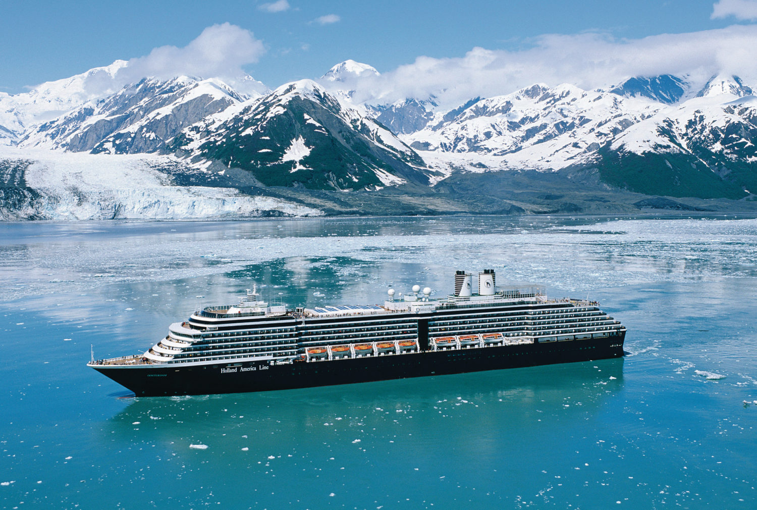 holland america cruise ship in alaska with ice capped mountains