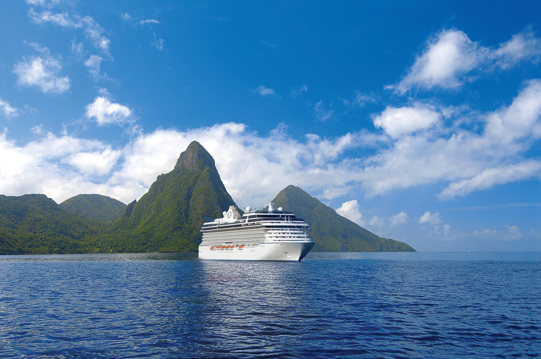 oceania cruise ship with mountains behind it