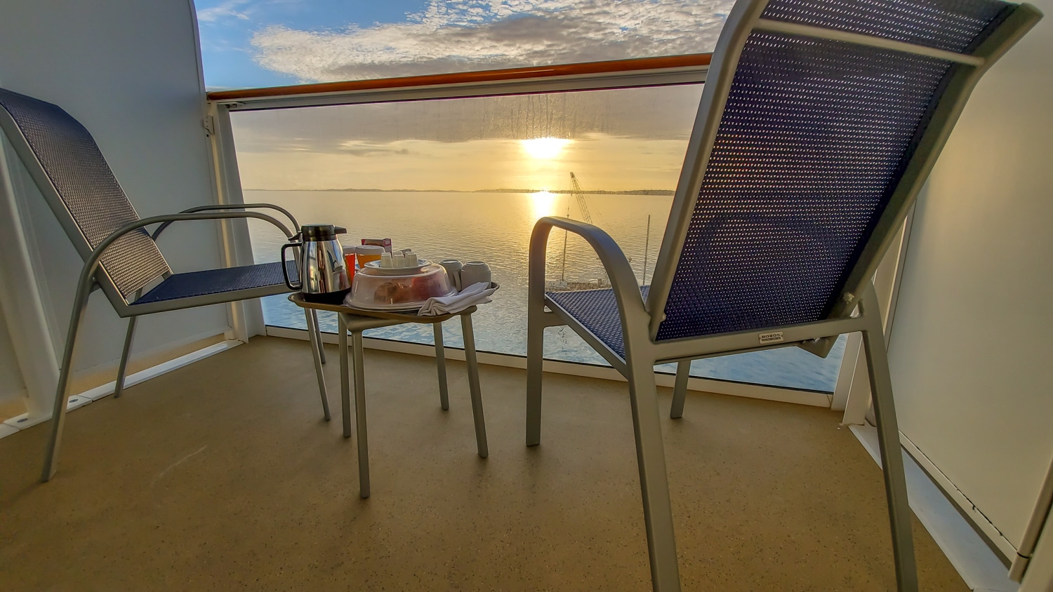Norwegian Escape balcony with room service breakfast on tray with sunrise