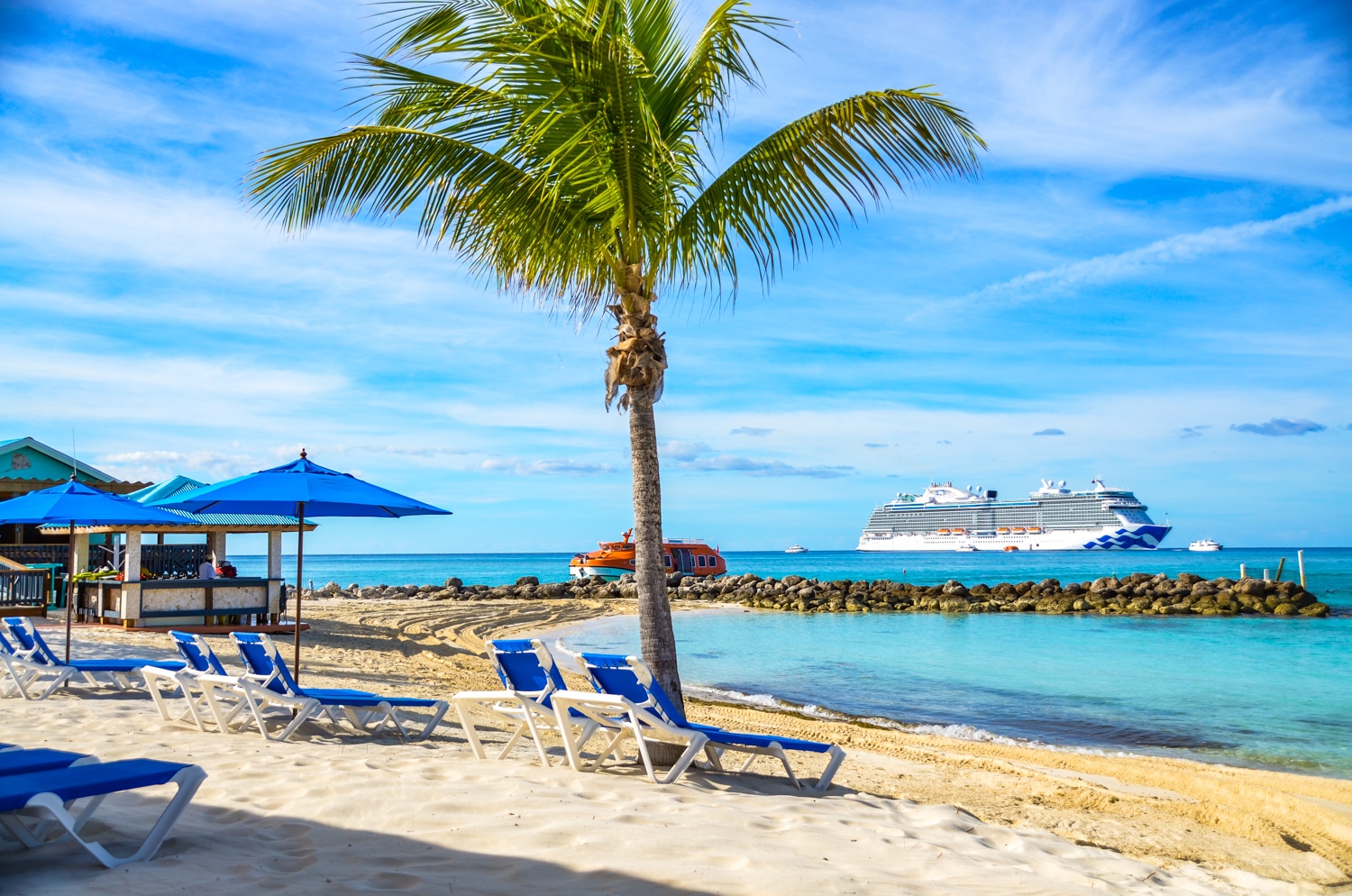 Sky Princess at Princess Cays, private island in the Caribbean. Lounge chairs on the beach with palm tree.