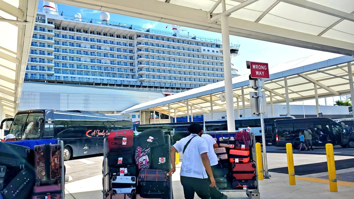 luggage on a cruise with porters with cruise ship in background in PortMiami
