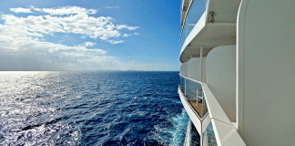 Side of a cruise ship from a balcony stateroom showing the sea on a sunny day