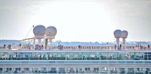 23 Changes Cruise Passengers Want to See in 2024 Image of cruise ship from side, top deck as it sails out of port