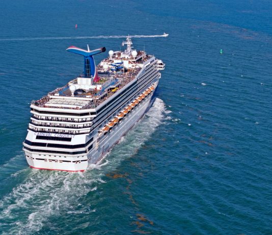 Carnival Conquest sailing out to sea from port