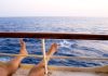 Man on cruise ship balcony relaxing