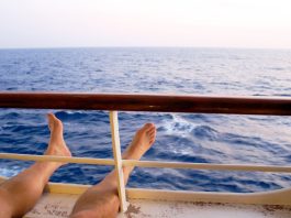 Man on cruise ship balcony relaxing