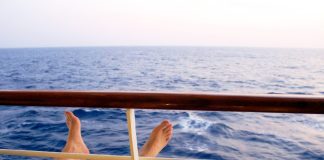 Man on cruise ship balcony relaxing
