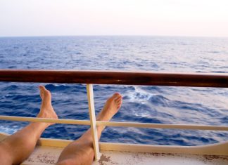 Man on cruise ship balcony relaxing