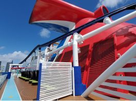 Carnival cruise line ship's whale tail on top deck with city in background