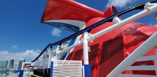 Carnival cruise line ship's whale tail on top deck with city in background