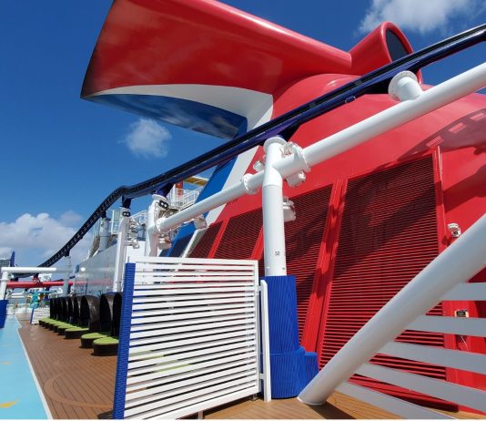 Carnival Sends Reminder for VIFP Cruisers to “Enroll and Accept” Before September Deadline Carnival cruise line ship's whale tail on top deck with city in background