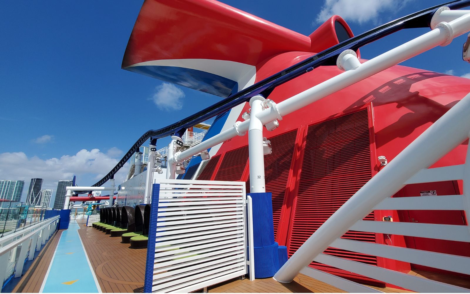 Carnival cruise line ship's whale tail on top deck with city in background